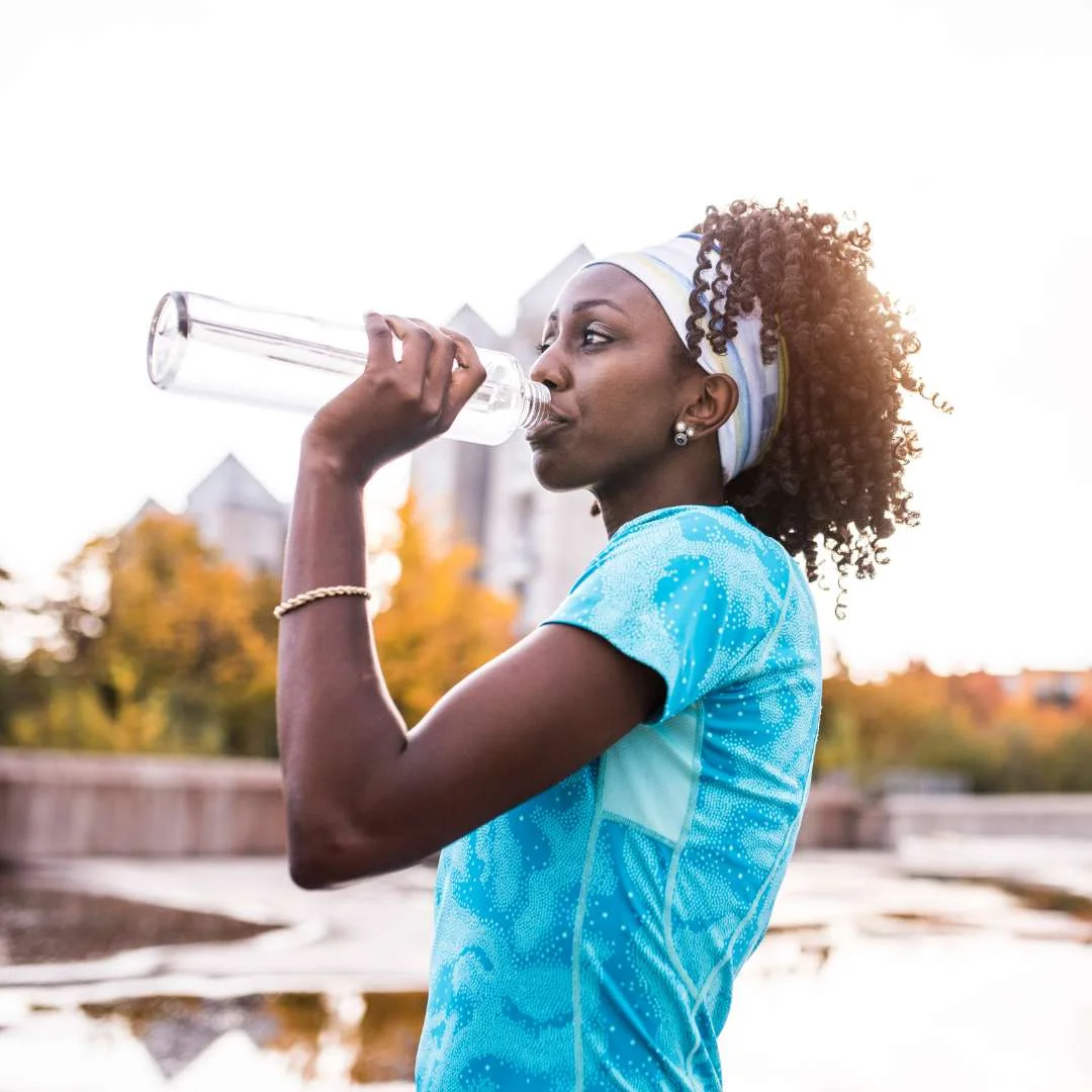 lady athlete drinking water after her workout