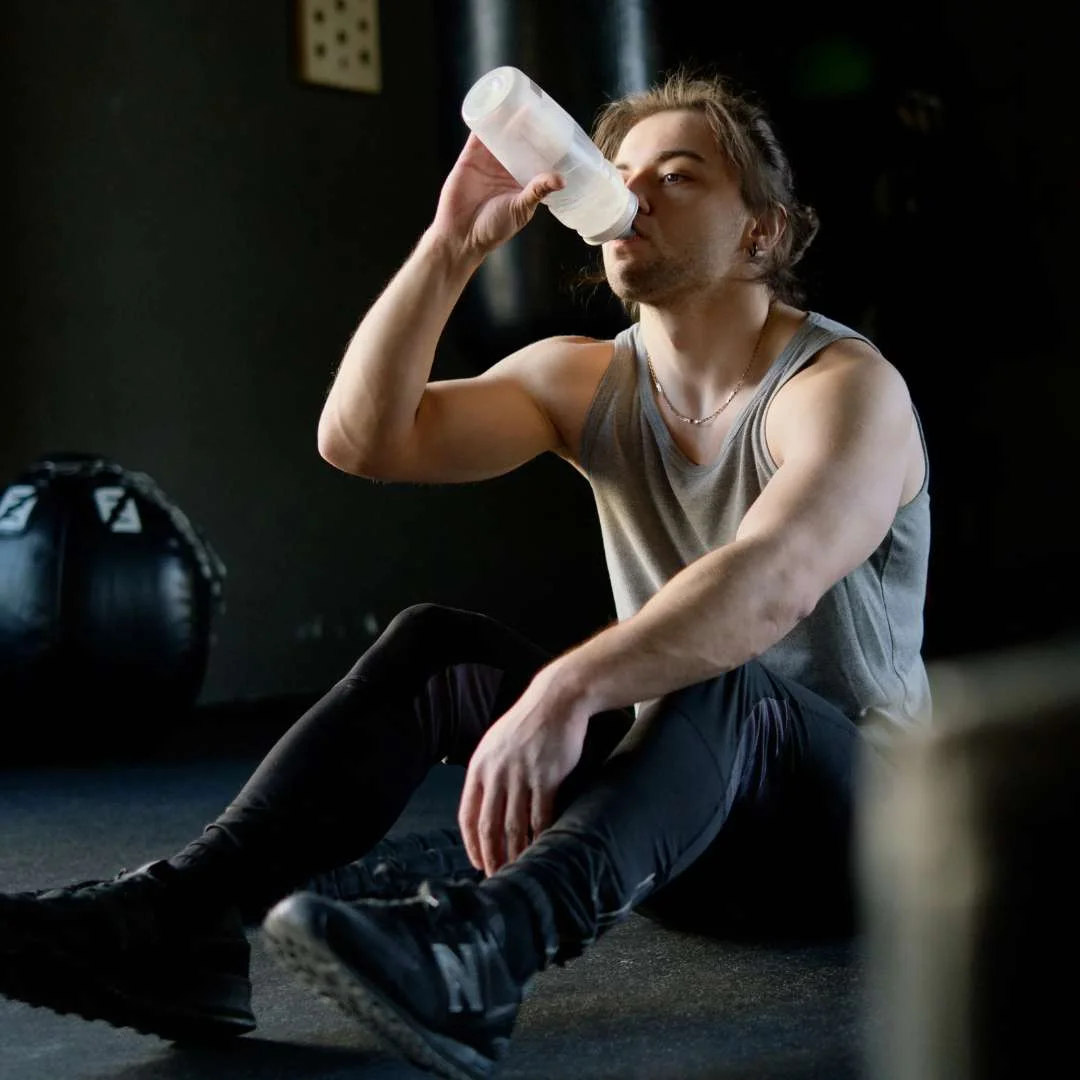 man drinking water during his workout